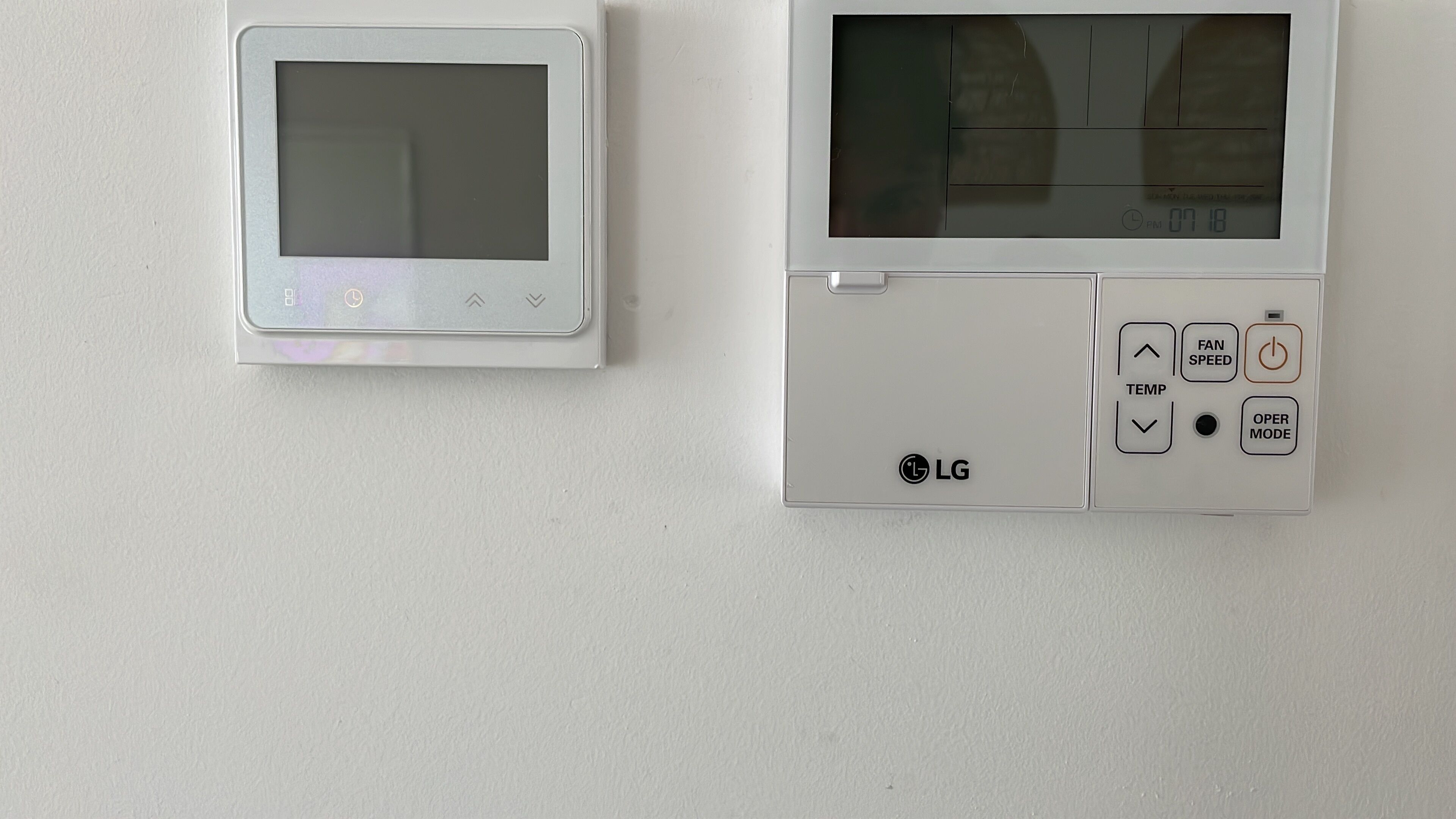 Dois termostatos LG fixados na parede, um com visor maior e outro com visor menor.