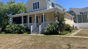 A two-story house with a front porch, a covered entryway, and a visible staircase leading to the front door. - Pool, Pet Friendly, Close to Beach (Cape May)