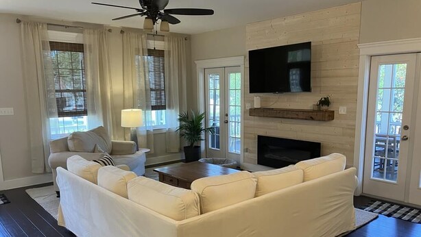 A living room with a beige sectional sofa, a coffee table, a TV mounted on the wall, and a fireplace. - Pool, Pet Friendly, Close to Beach (Cape May)