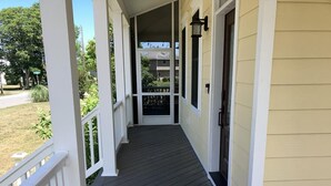 A covered porch with a dark wooden floor and white railings. - Pool, Pet Friendly, Close to Beach (Cape May)