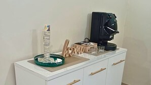 A white cabinet with four drawers and a coffee machine on top.