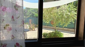 A window with a view of a tree and a garden. - SE115 - Marotta, comfortable two-room apartment with parking (Marotta)