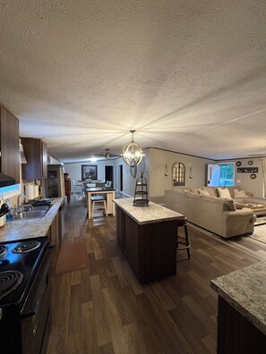 A spacious living area with a kitchen, a dining area, and a seating area with a sofa and coffee table. - Sleeps 10 • 4BR • 2BA • 4 Acres • Pet Friendly • Firepit • Grill (Phenix city)
