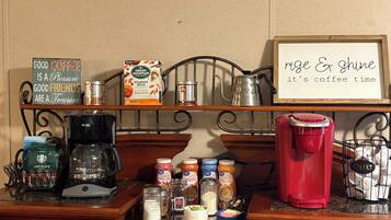 A kitchen counter with coffee-making equipment, a sign that says 'nice & shine it's coffee time,' and various coffee-related items.