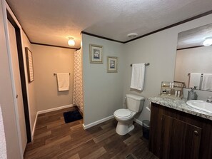 Een badkamer met toilet, wastafel en douche.