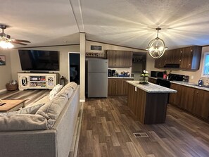 Una cocina moderna con armarios de madera, una isla integrada y un refrigerador grande.