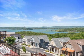 A row of houses with a view of a lake and hills in the background.