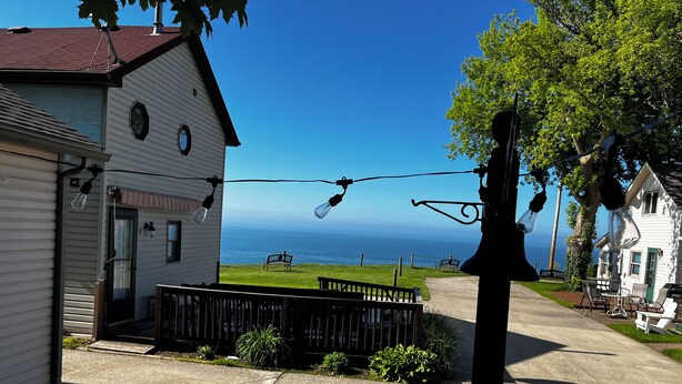 A coastal house with a porch, a dog, and a view of the ocean. - Lake front updated cabin-close to everything!! (Ashtabula)