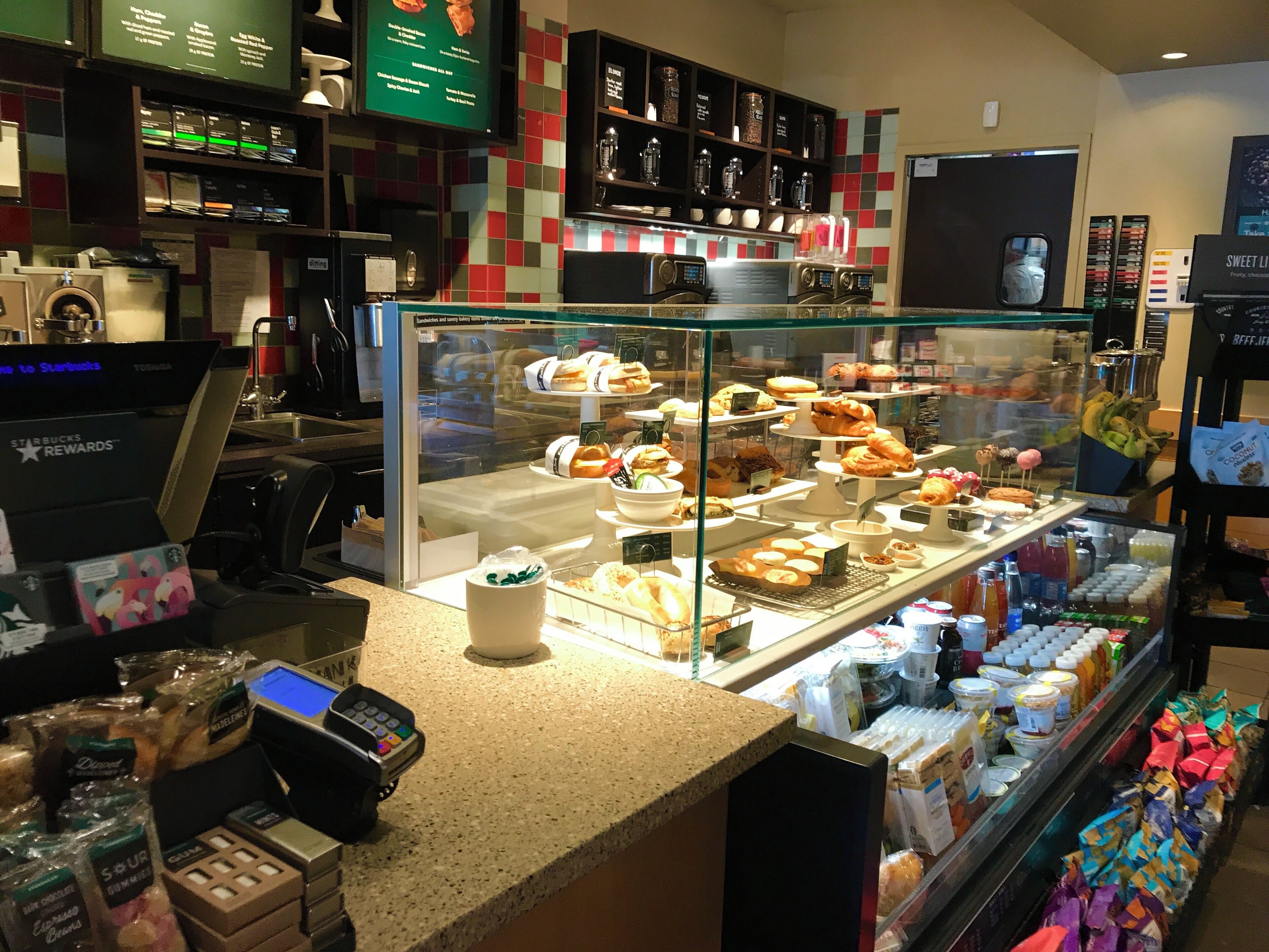 A bakery display case with various pastries and a coffee machine.