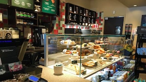 A bakery display case with various pastries and a coffee machine.