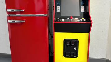A red Galanz refrigerator and a black and yellow arcade machine with Pac-Man and other characters.