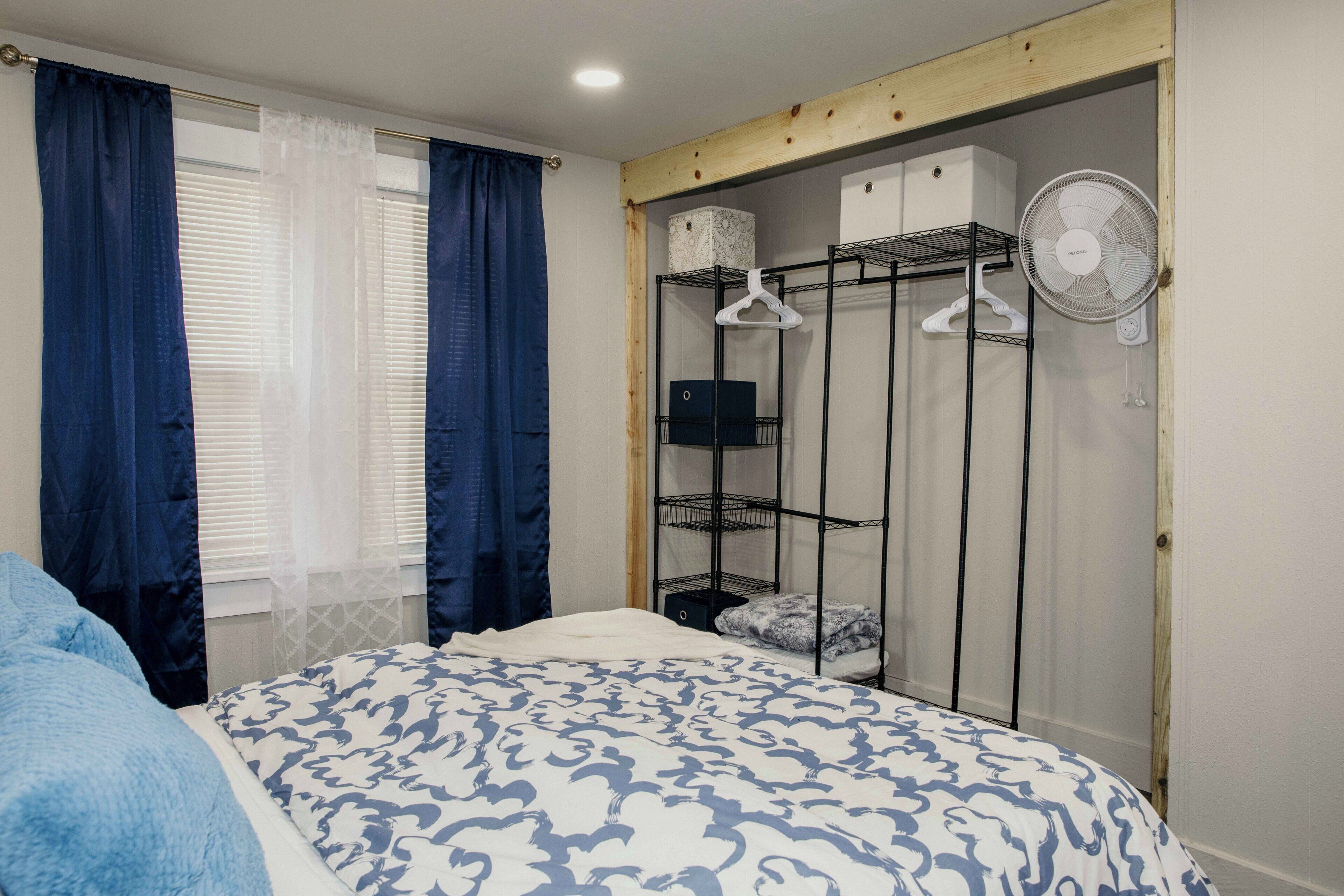 A bedroom with a bed, a wardrobe, and a ceiling fan.