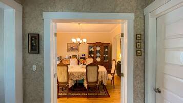 A dining area with a table, chairs, a chandelier, and a china cabinet.