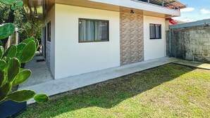 A modern two-story house with a flat roof, large windows, and a covered patio area. - Cozy 2-bedroom apartment in charming La Fortuna with WiFi, AC (La Fortuna)