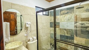 A bathroom with a marble sink, toilet, and a glass-enclosed shower area. - Cozy 2-bedroom apartment in charming La Fortuna with WiFi, AC (La Fortuna)