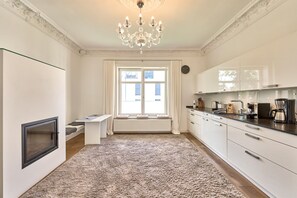 A modern kitchen with a large window, a chandelier, and a built-in stove.