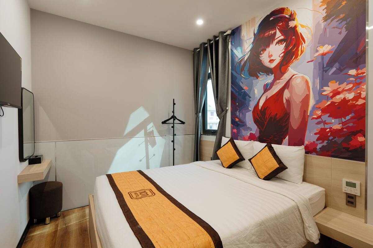 A modern hotel room with a large bed, a bedside table, a digital thermostat, and a large window with curtains.