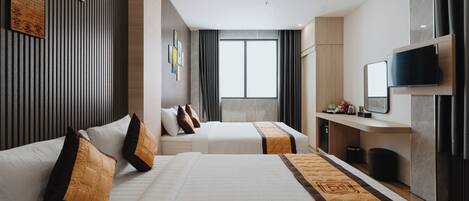 A hotel room with two beds, a TV, a desk, and a large window.