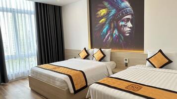 A hotel room with two beds, a large window with curtains, and a wall-mounted screen displaying a colorful image.