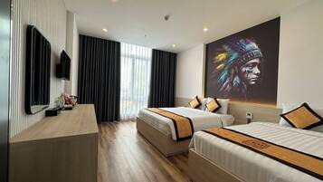 Habitación de hotel con dos camas, un escritorio, un televisor y un cuadro grande en la pared.