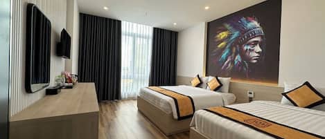 A hotel room with two beds, a desk, a TV, and a large painting on the wall.