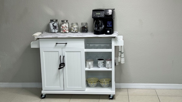 Kitchen essentials at your fingertips, this mobile cart offers a coffee maker and ample storage.