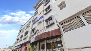 Ένα πολυώροφο κτίριο με μια πινακίδα που αναγράφει «Hotel Paradise» και μια άλλη πινακίδα που αναγράφει «Tad Hotels».