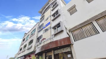 A multi-story building with a sign for 'Hotel Paradise' and another sign for 'Tad Hotels'.
