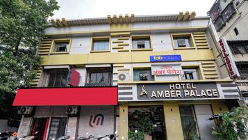 Un edificio de varios pisos con un letrero que dice 'Hotel Amber Palace' y otro letrero que indica 'fab hotels'.