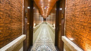 Ein Korridor mit gemustertem Bodenbelag, Holzvertäfelung und einer Decke mit eingelassener Beleuchtung.