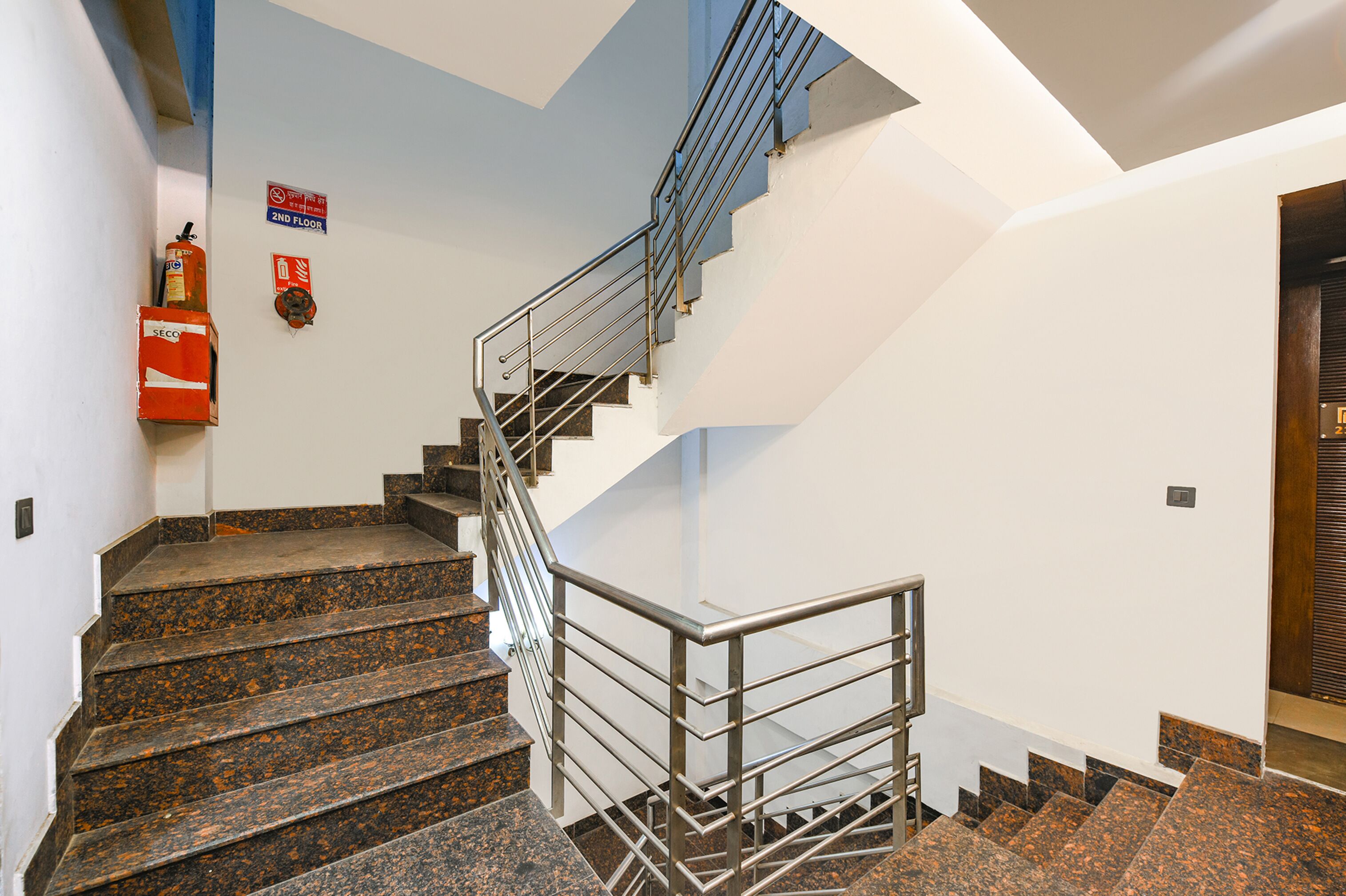 A staircase with metal railings and granite steps leading to the second floor.