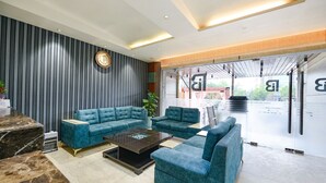 Eine moderne Lobby mit Ecksofa, Couchtisch und Rezeption.