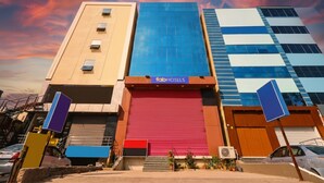 A hotel with a red shutter, a blue facade, and a sign reading "fato hotels". - FabHotel Galaxy Suites (Hyderabad)