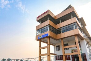 Un edificio de varios pisos con un letrero que indica 'Brand Jivi Resort' y 'Fab Hotels'.