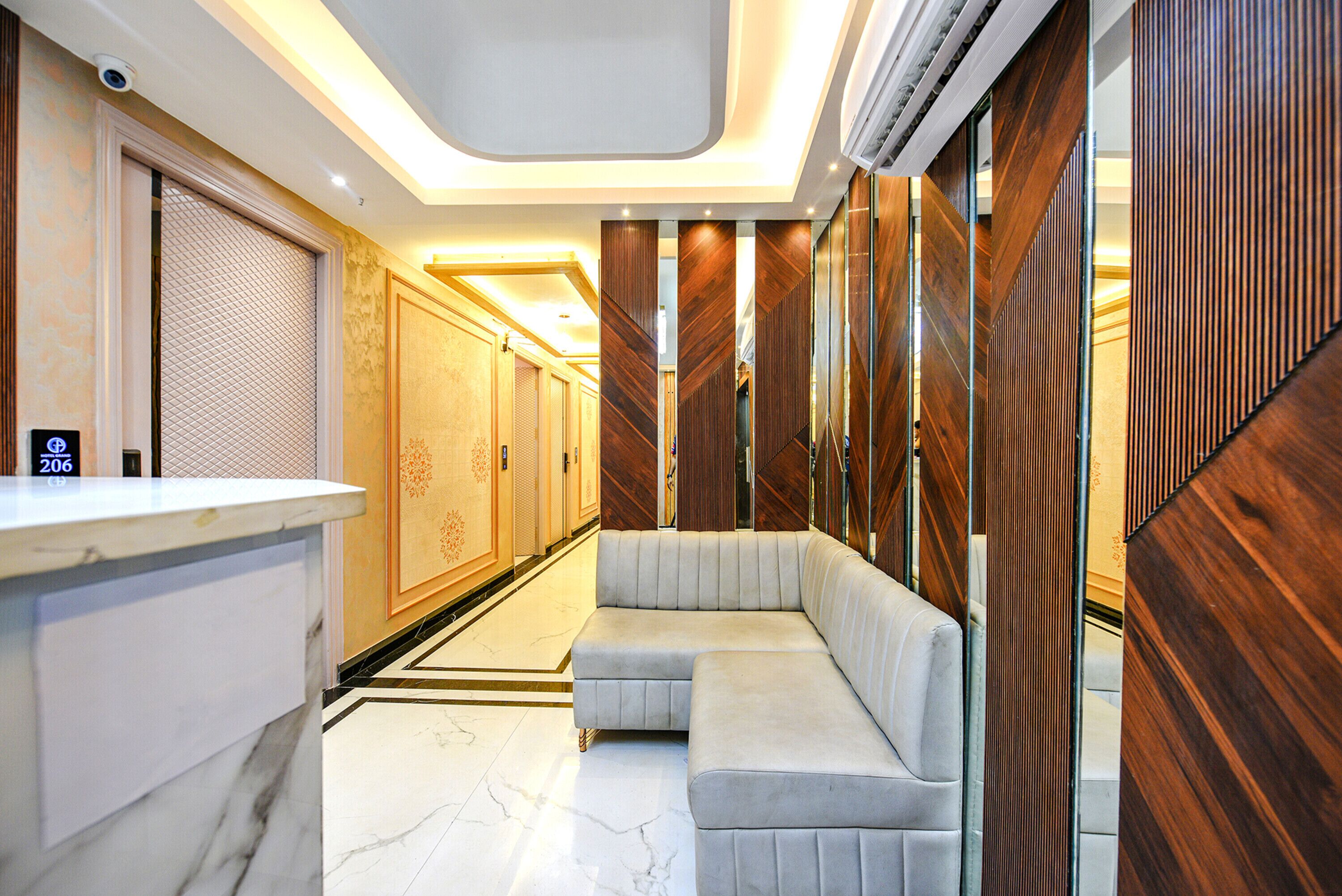 Un moderno vestíbulo de hotel con mostrador de recepción, zona de estar y paneles de madera.