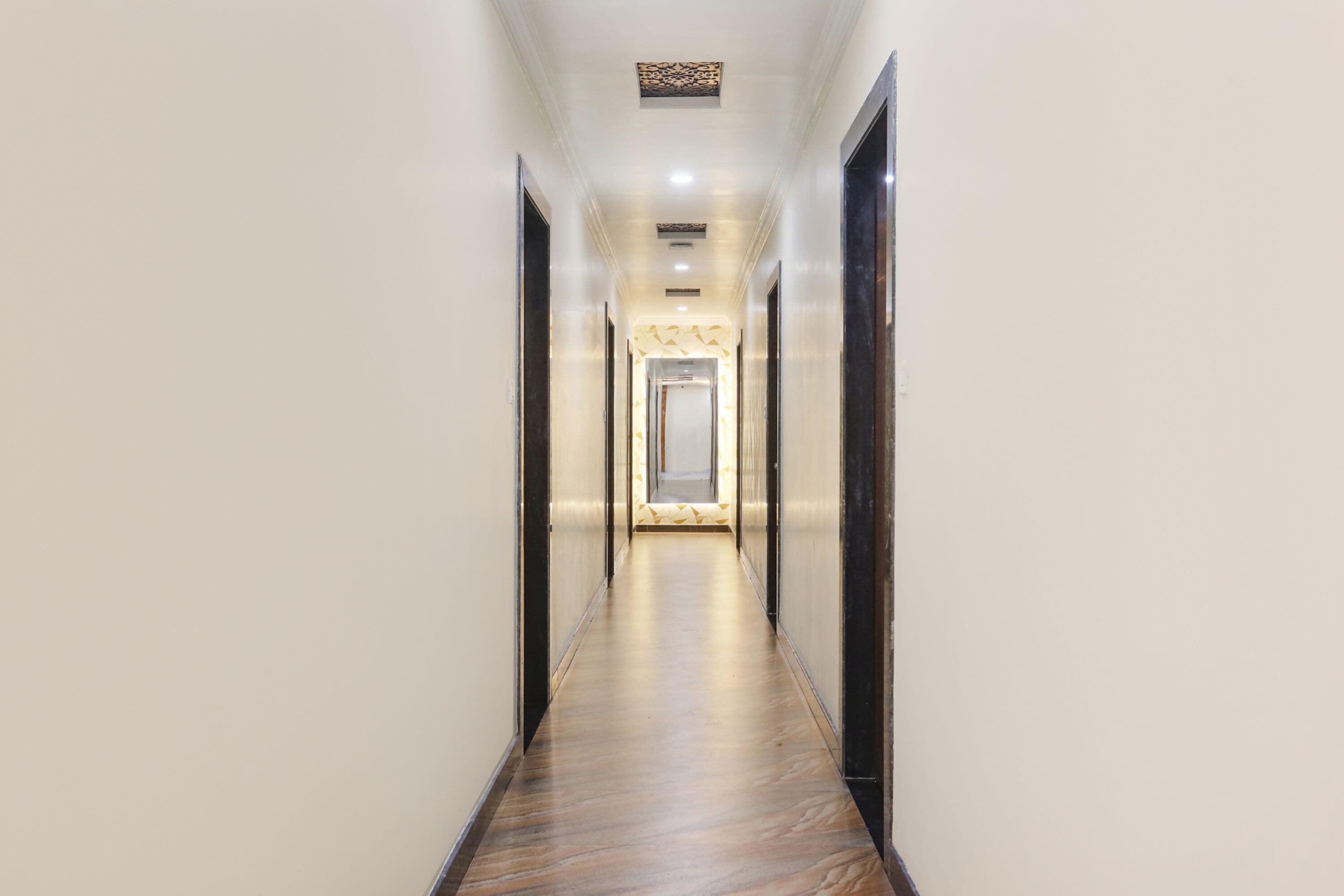 A long, narrow hallway with a wooden floor and light-colored walls.