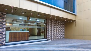 A hotel entrance with a reception desk, a patterned tile floor, and a decorative string of lights. - Fabhotel Heritage I (Durg)