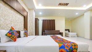 A hotel room with a large bed, a desk, and a chair. - Fabhotel Heritage I (Durg)