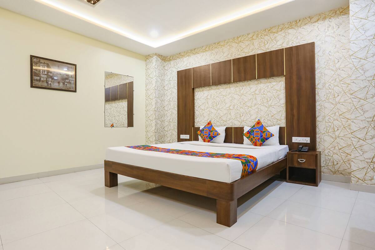 A modern bedroom with a wooden bed, a nightstand, and a mirror.