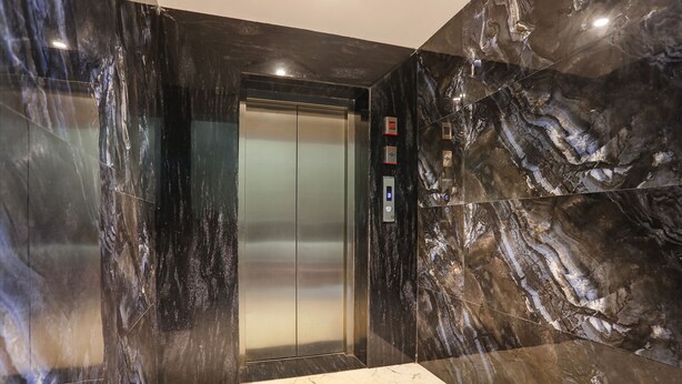 An elevator with a metallic finish and a control panel on the wall. - Fabhotel Heritage I (Durg)