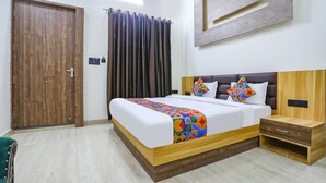 A neatly arranged bedroom with a wooden bed, a bedside table, and a wardrobe. - Fabhotel Jb Square Resort (Faizabad)