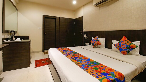 Habitación de hotel con una cama grande, un escritorio, un armario y un equipo de aire acondicionado.