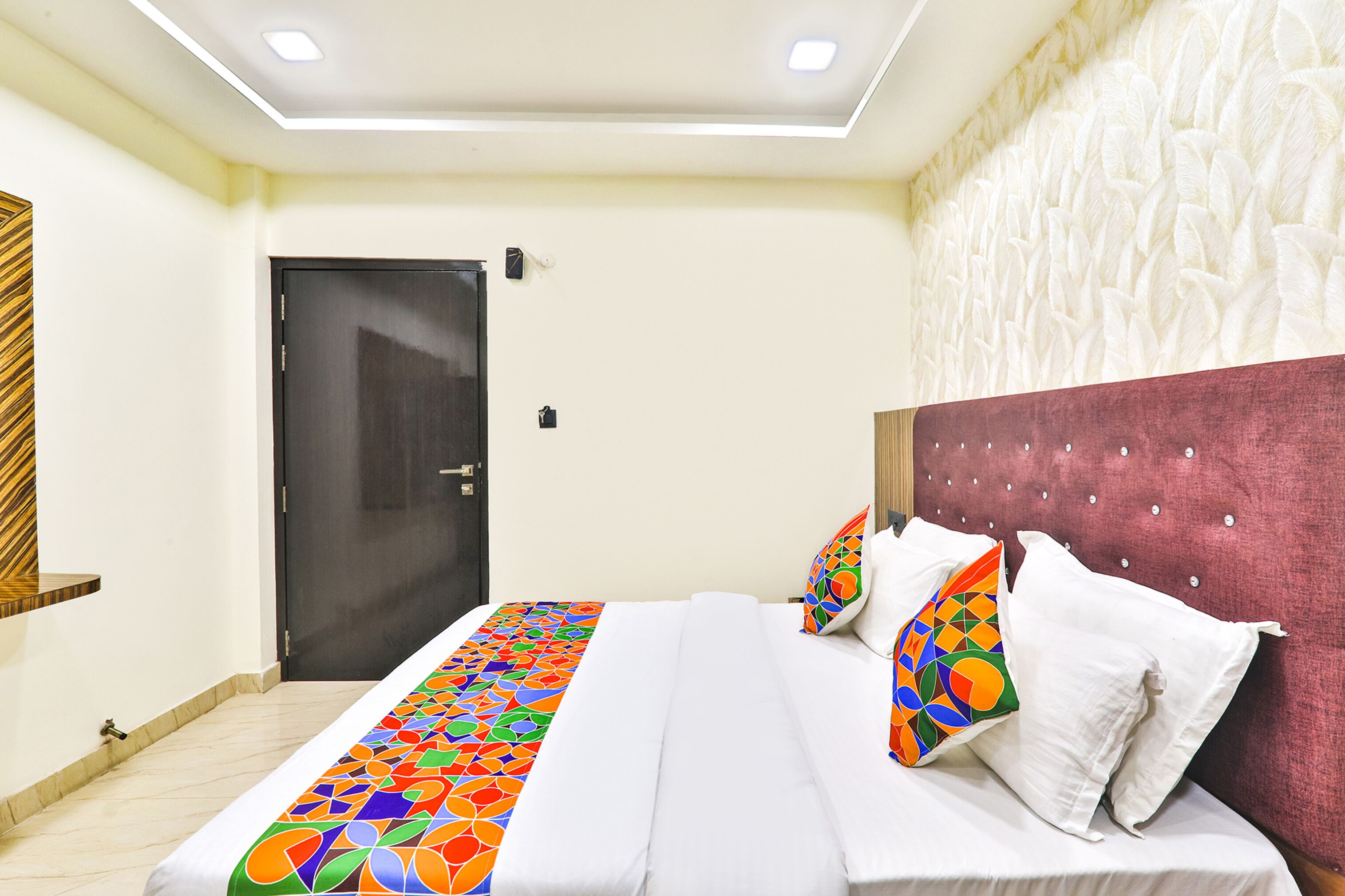 Une chambre d’hôtel avec un lit, une tête de lit et une porte.