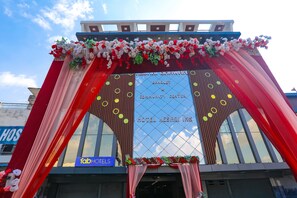 A hotel entrance with a red and white floral arch, a sign for the Banquet & Community Center, and a visible 'fab hotels' sign. - Fabhotel Keshri Inn (Prayagraj)