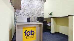 A reception desk with a 'fab hotels' sign, a computer, a printer, and a small plant on a shelf. - Fabhotel New Shraddha Inn (Nagpur)