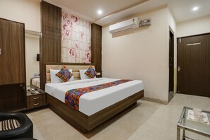 A bedroom with a bed, a wardrobe, a desk, and an air conditioning unit. - Fabhotel Orchid (Agra)
