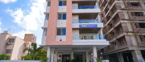 A multi-story hotel with a prominent 'fab hotels' sign on the ground floor.