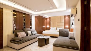Ein modernes Hotelzimmer mit Sofa, Ottoman und einem Bett.