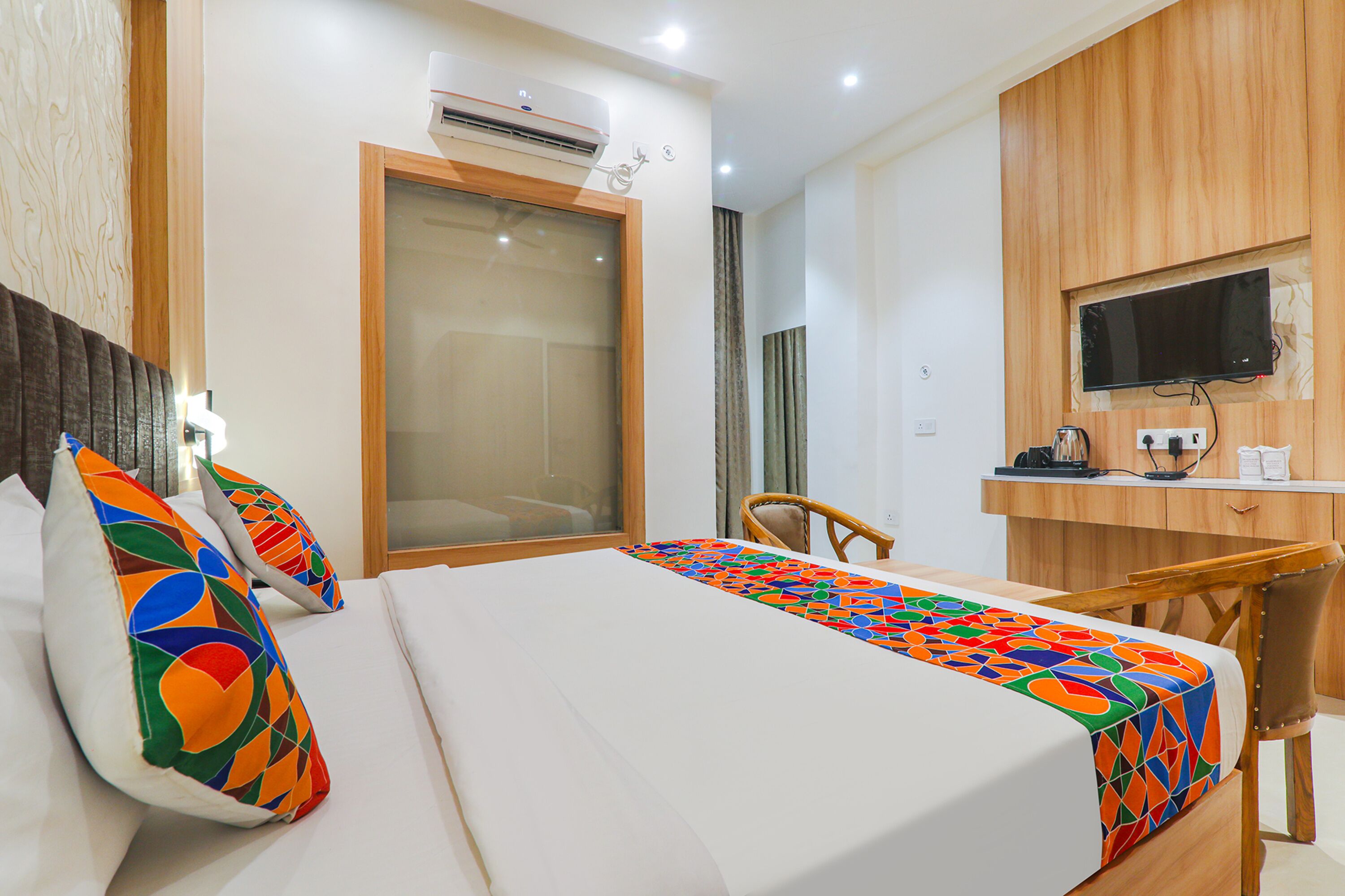 Une chambre d’hôtel équipée d’un lit, d’un bureau, d’une chaise et d’un téléviseur.