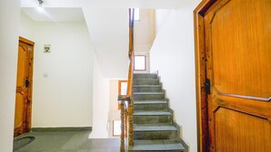 A staircase with wooden railings leading to a landing. - Fabhotel Saurabh Inn (Manali)